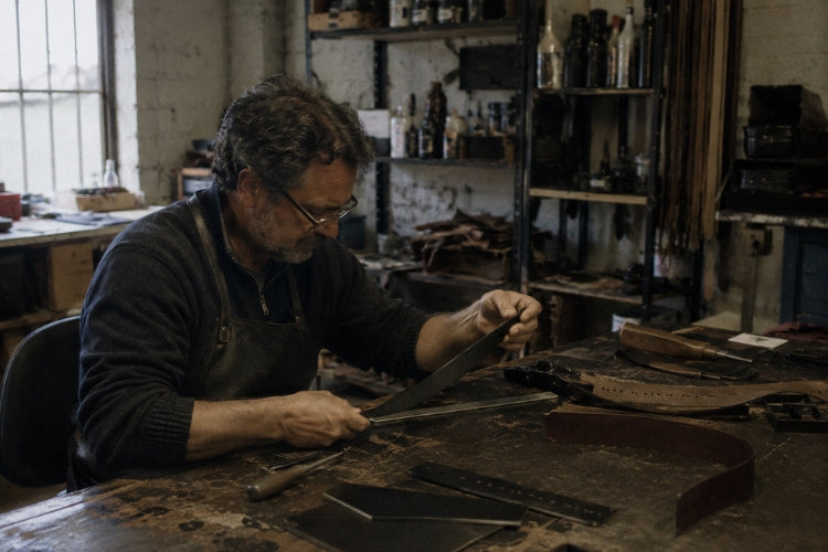 Leather being cut to length at a workbench