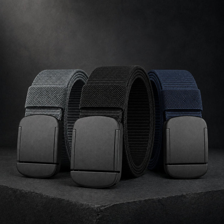 All three colours of The Everyday Belt on a dark surface: grey, black and navy